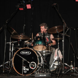 Paul Maclennan playing the drums on stage